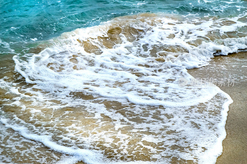 马略卡岛帕尔马海滩的金色沙滩上，蓝色海水的白色泡沫和热带海浪
