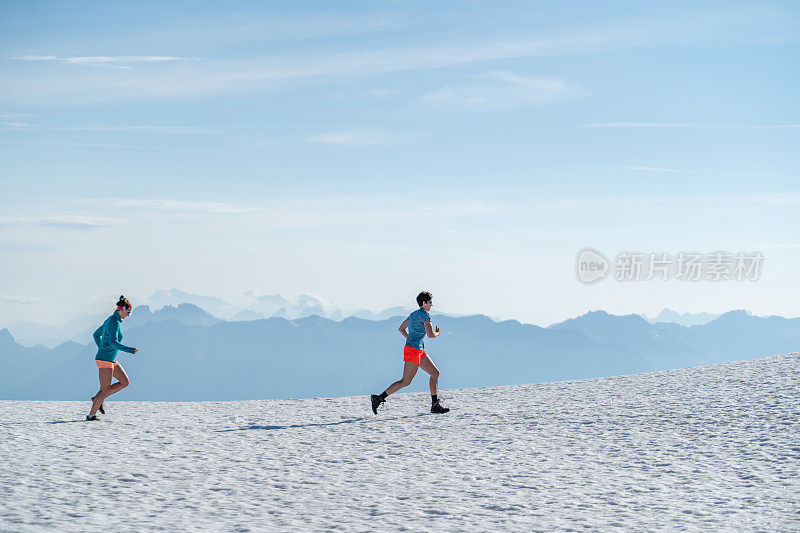 女性越野跑者穿过雪山山脊