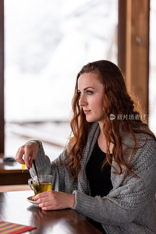 漂亮的年轻女人在咖啡馆喝茶存货照片