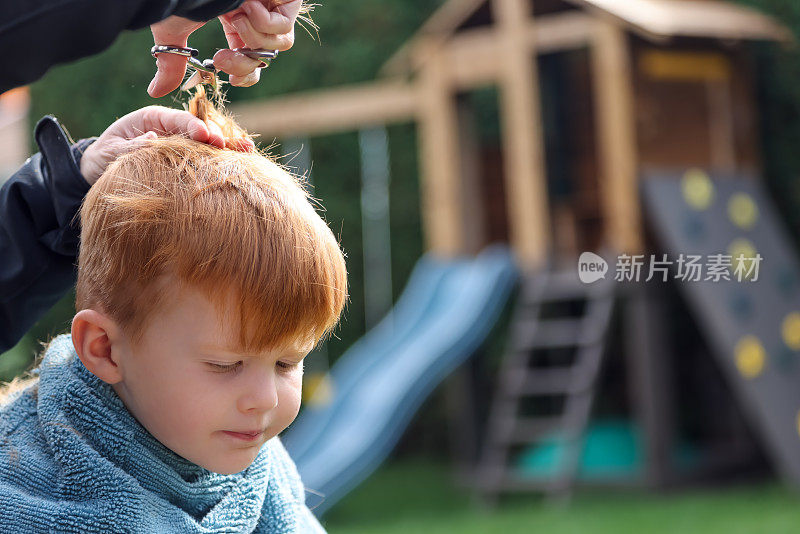 可爱的红发小男孩在外面理发