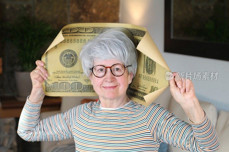 老妇人手里拿着一张巨大的100美元钞票