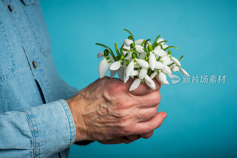 男人捧着雪花莲花束