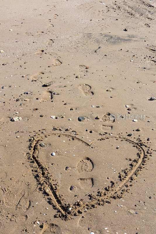 沙滩上的脚印和心形印记