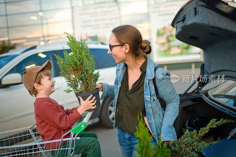 在花园中心购物后，家人把植物放在停车场的车里