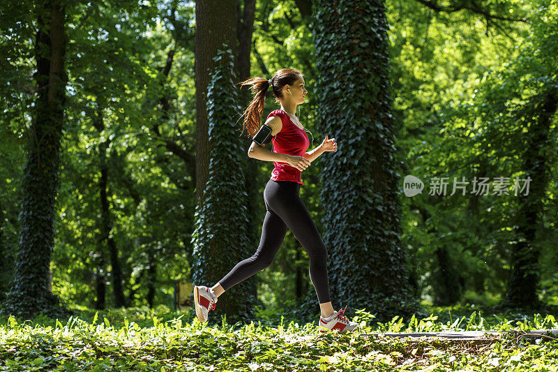 运动的年轻女人在外面跑步。