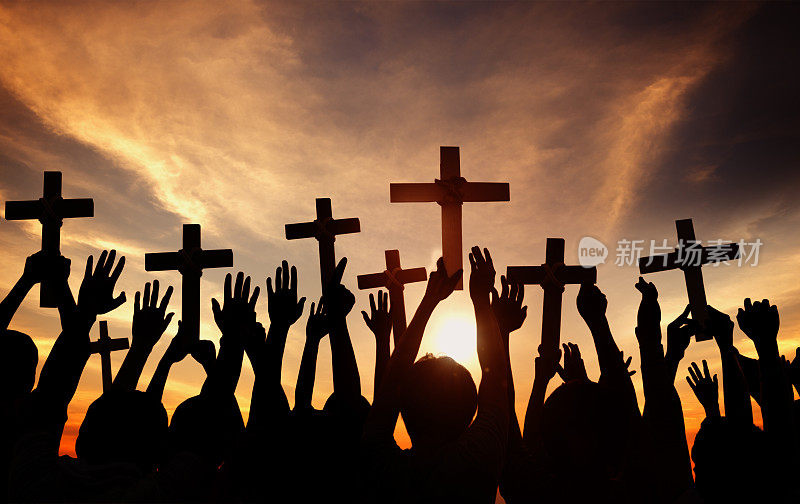 一群人抱着十字架，在背光祈祷