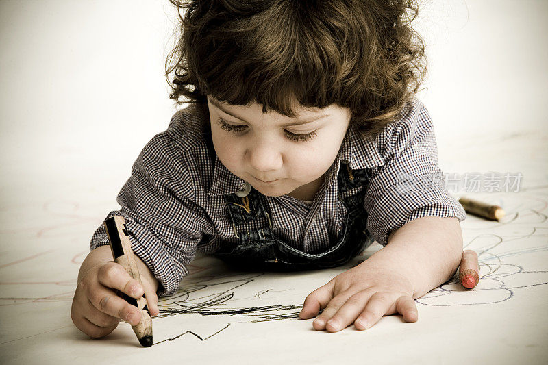 一个小男孩用蜡笔画画