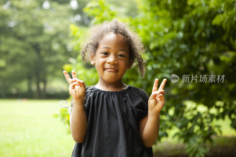 拿着胜利手势的小女孩