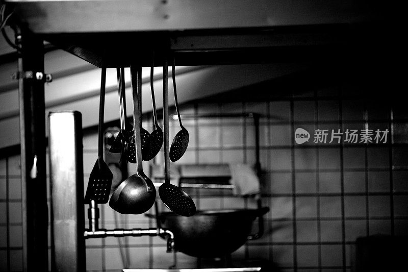 悬挂厨房用具的黑白图像