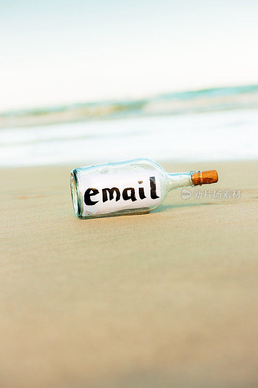 海滩上的漂流瓶上写着“电子邮件”:现代漂流者!