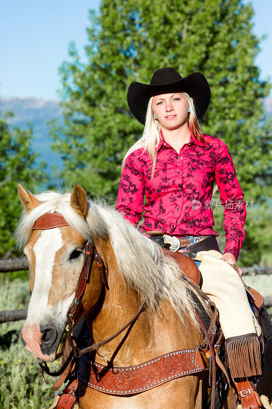 女牛仔肖像骑马在红衬衫