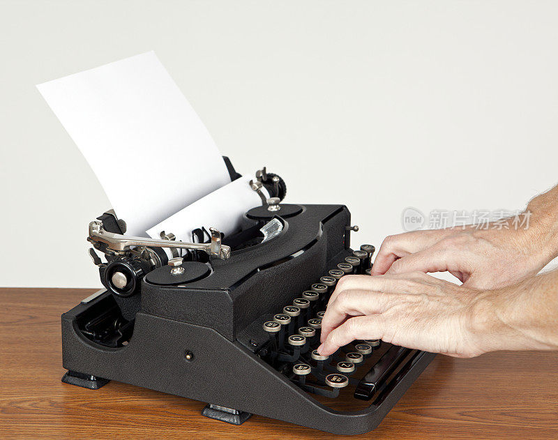 双手握着打字机的按键。