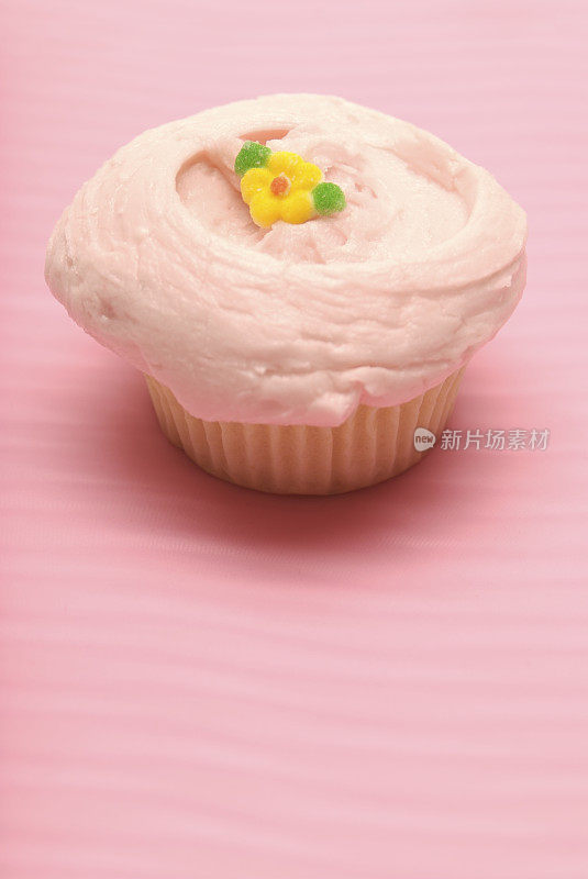 粉色糖霜和背景纸杯蛋糕