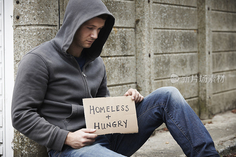无家可归的年轻人在街上乞讨