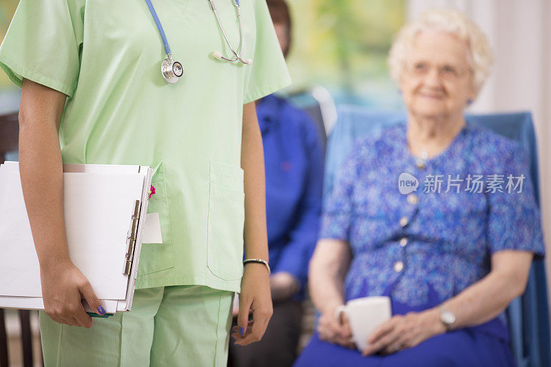 护士或医生到养老院看望老年妇女病人。