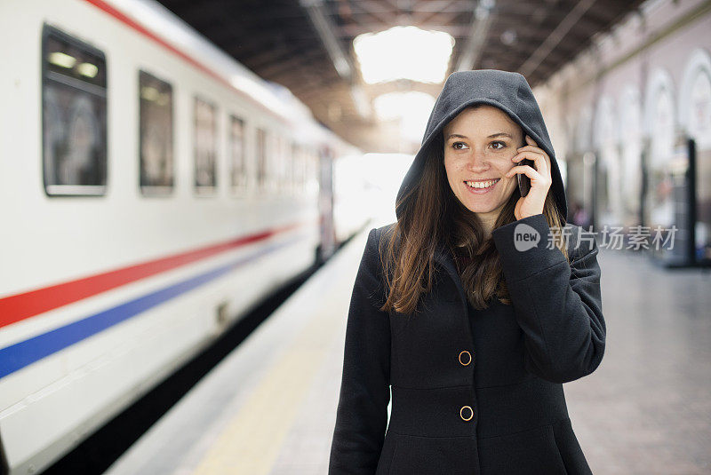 一个年轻女子在火车站打电话