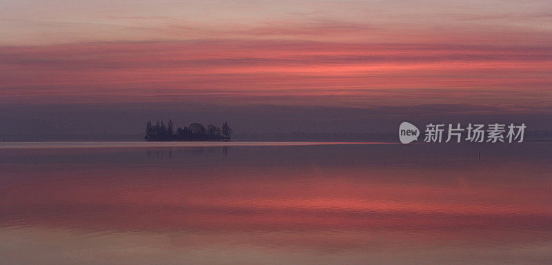 黎明时分湖面映照出美丽的红色天空