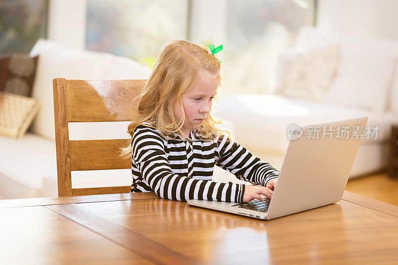 小女孩在用笔记本电脑工作
