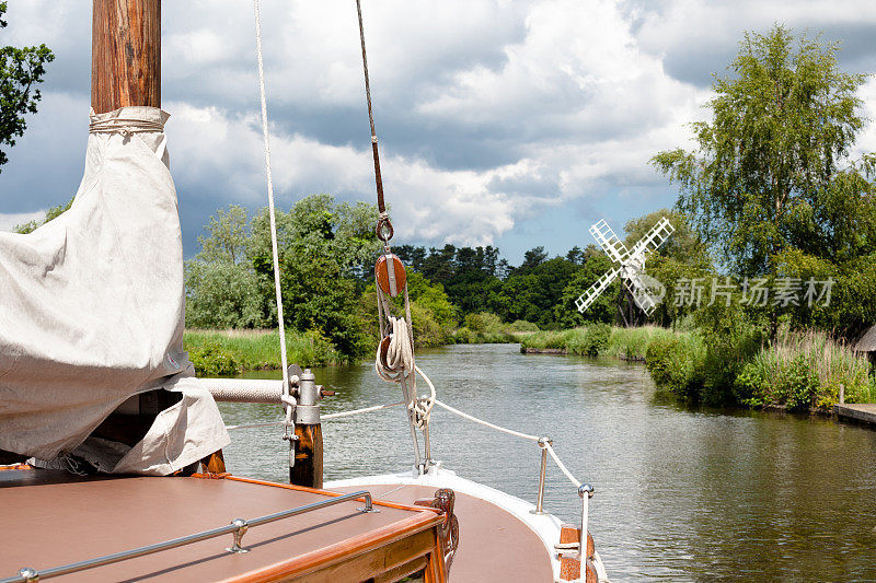 英国诺福克郡的河面上有一艘帆船和风车