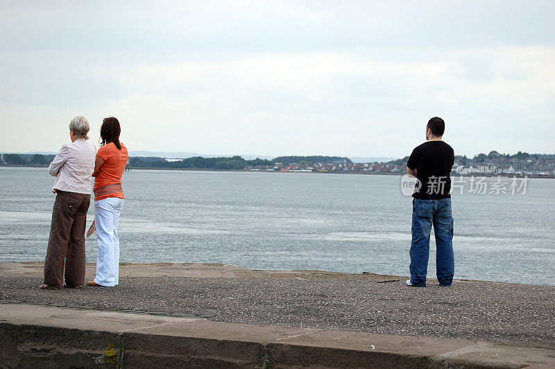 三个人在苏格兰海岸眺望大海