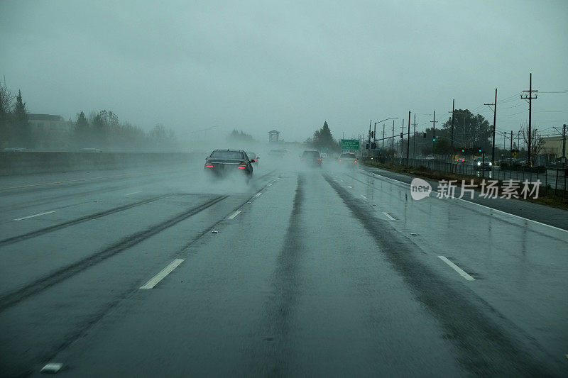 几辆汽车在雨中行驶在高速公路上