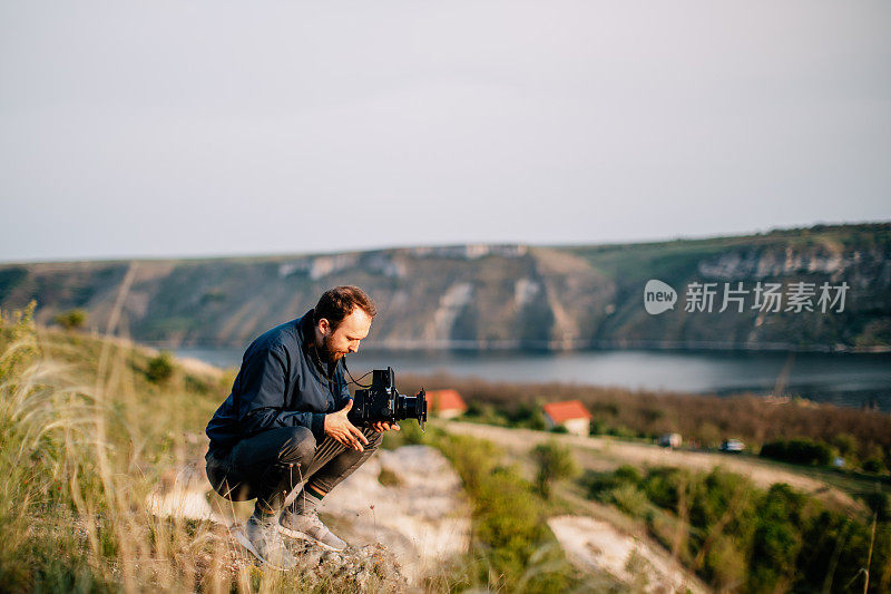 一个年轻人正在用胶卷相机拍照