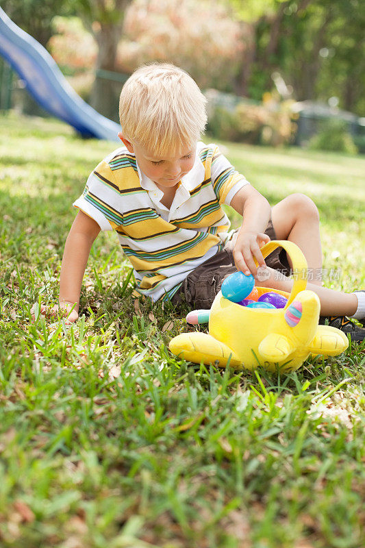 小男孩在公园里玩玩具篮子