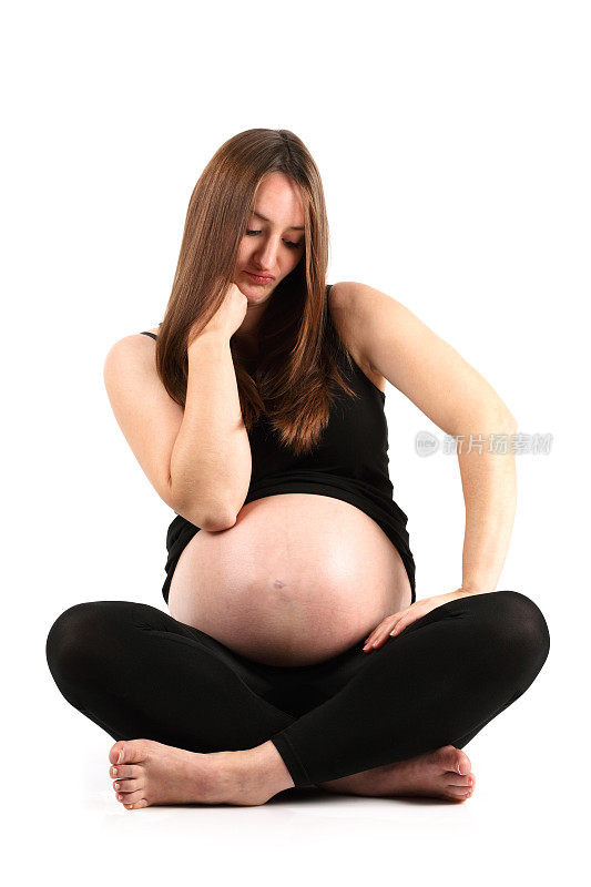 不耐烦的盘腿相当满意的年轻孕妇