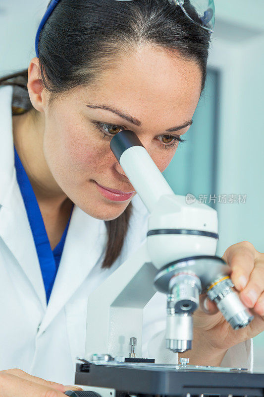 女科学家在实验室里使用显微镜的女性医学或研究科学家