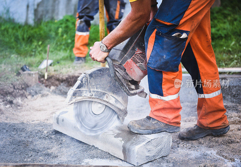 建筑工人切割混凝土、铺路刀或金属