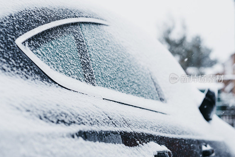 黑色的汽车上覆盖着雪，车窗上结着冰