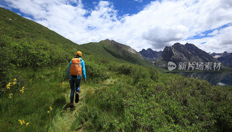 在山里徒步旅行的年轻背包女