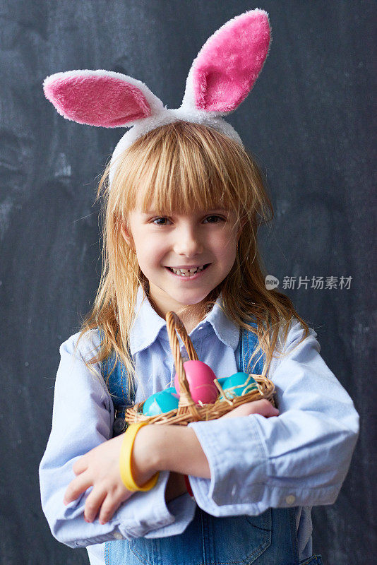 积极可爱的复活节兔子拥抱篮子与鸡蛋