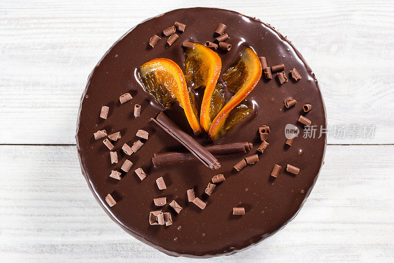 巧克力蛋糕与蜜饯橘子，巧克力蛋糕与切块和刀片在灰色的背景，特写，黑巧克力蛋糕，美味的素食巧克力蛋糕，美味的巧克力蛋糕在木制的背景