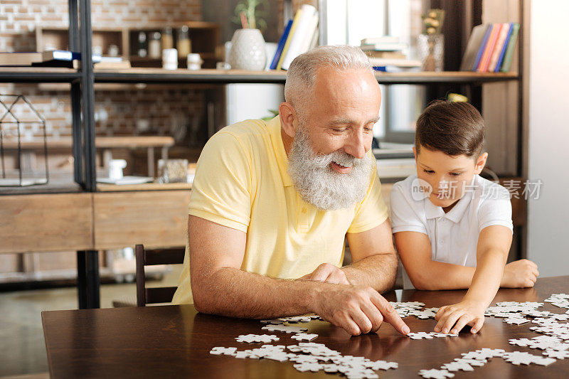 快乐的爷爷和孙子一起玩拼图