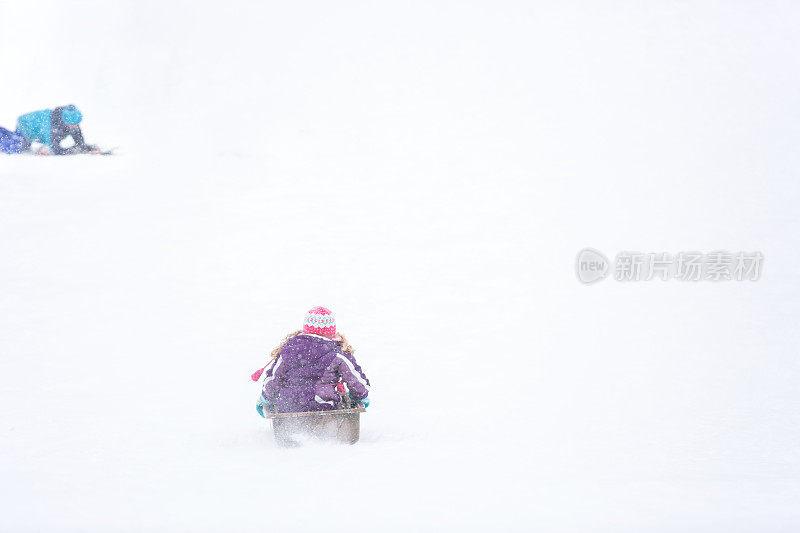 女孩在雪天滑下山