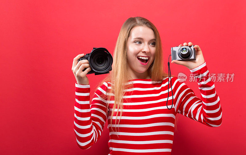 比较专业相机和袖珍相机的年轻女子