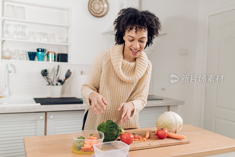 美丽的非洲裔美国女人切菜准备午餐