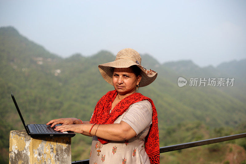 印度喜马偕尔邦山区，成年女性在户外使用笔记本电脑