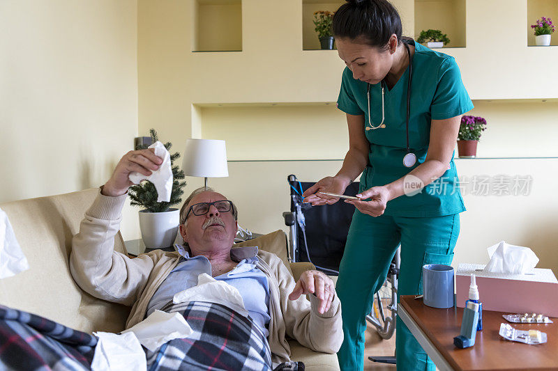 细心的护士协助老人进行家访，并检查他的体温。