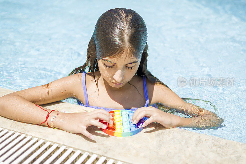 美丽的女孩享受抗压力彩虹在游泳池烦躁