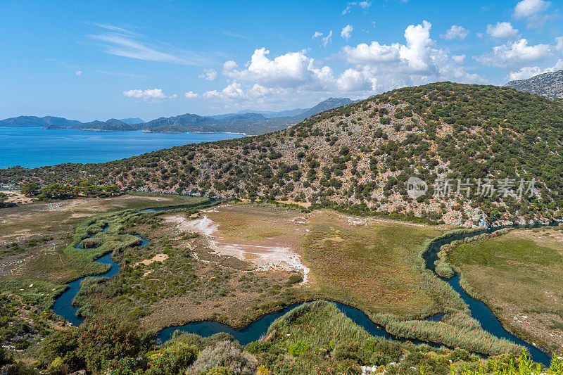 曲曲折折的小溪在群山之间流入大海。海山云海