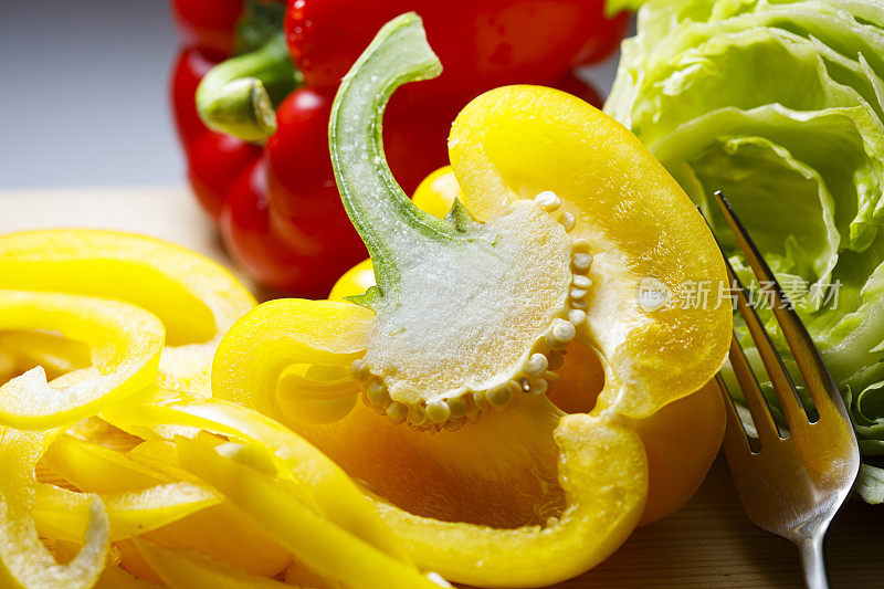 黄色甜椒与红色甜椒和生菜一起切成薄片