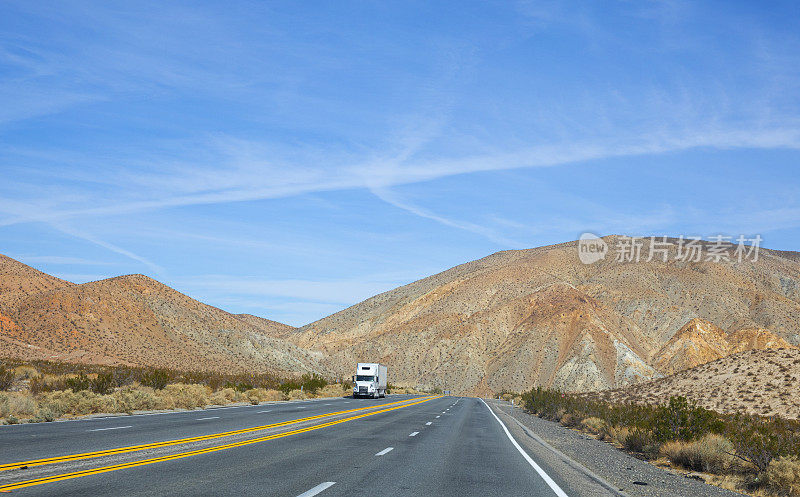 白色卡车在空荡弯曲的沙漠道路上，加利福尼亚，美国