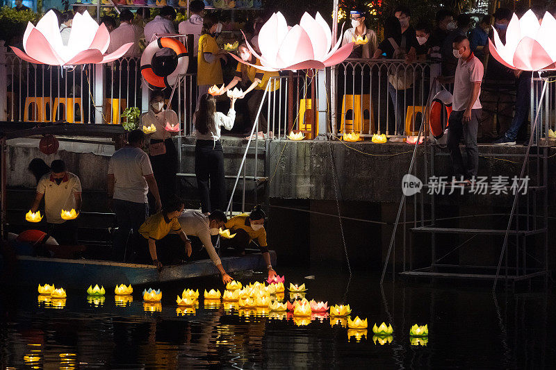 夜里在西贡河上，用纸和蜡烛做成的彩灯和花环漂浮在河上，纪念那些逝去的人们。