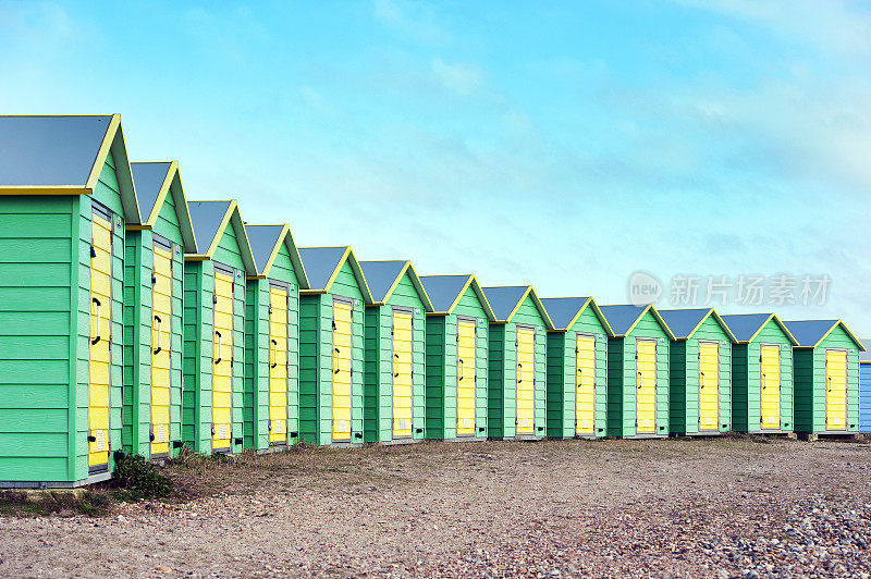 英格兰西苏塞克斯郡，利特尔汉普顿，绿黄相间的新月形海滩小屋