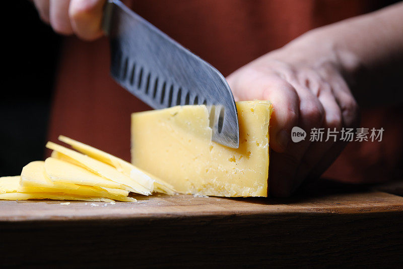 人手正在切一片奶酪