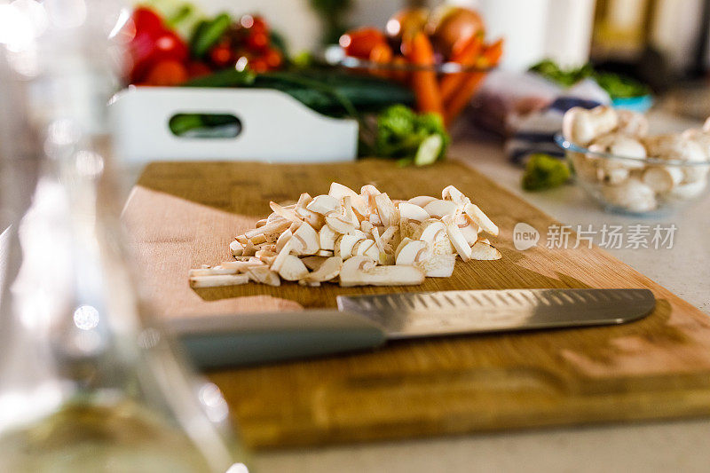 一小堆切碎的蘑菇放在木切菜板上