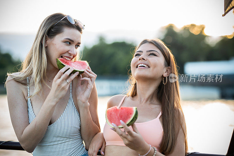 姑娘们在河船上吃西瓜