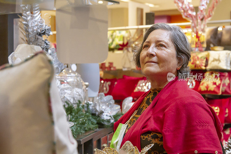 一个成熟的女人在市中心逛圣诞购物